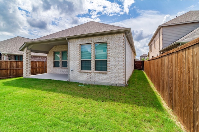 rear view of house featuring a yard and a patio