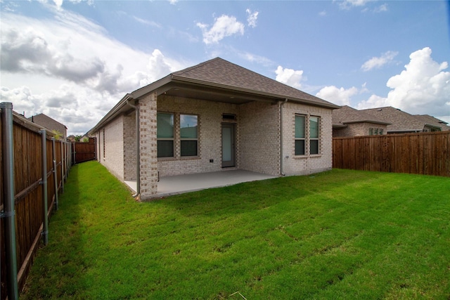 back of house with a lawn and a patio area