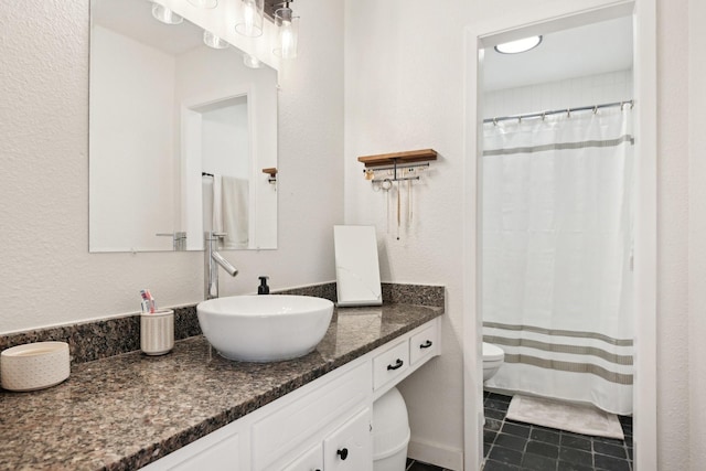 bathroom with tile patterned flooring, vanity, and toilet