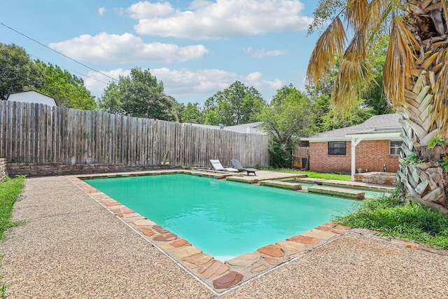 view of swimming pool featuring a jacuzzi and a patio