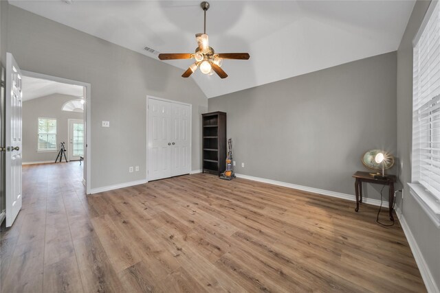 unfurnished room with lofted ceiling, ceiling fan, and light hardwood / wood-style flooring