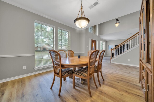 kitchen with a kitchen island, pendant lighting, light hardwood / wood-style floors, black appliances, and light stone countertops