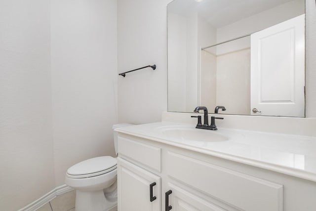 bathroom with toilet, vanity, and tile patterned floors