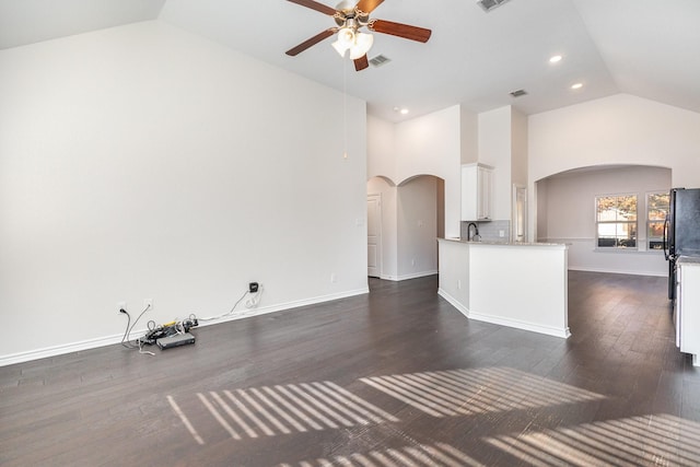 unfurnished living room with ceiling fan, sink, dark wood-type flooring, and high vaulted ceiling