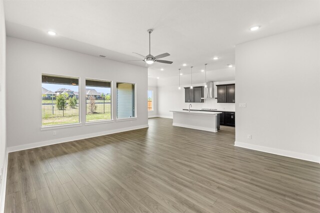 unfurnished living room with recessed lighting, ceiling fan, wood finished floors, and baseboards