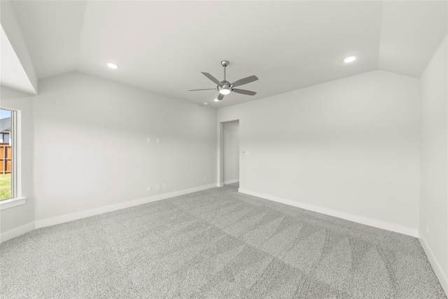 spare room with baseboards, a ceiling fan, carpet flooring, and vaulted ceiling