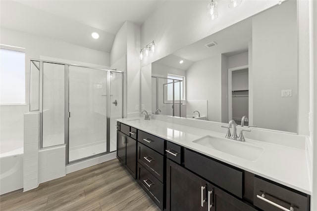 bathroom featuring a garden tub, a stall shower, double vanity, and a sink