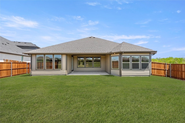 back of property with a yard, a shingled roof, a fenced backyard, and a patio area