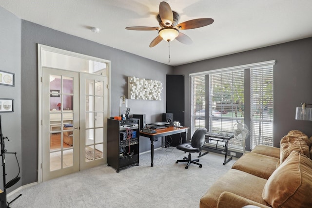 carpeted home office featuring french doors and ceiling fan