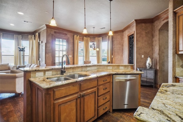 kitchen featuring dark hardwood / wood-style floors, pendant lighting, sink, stainless steel dishwasher, and a center island with sink