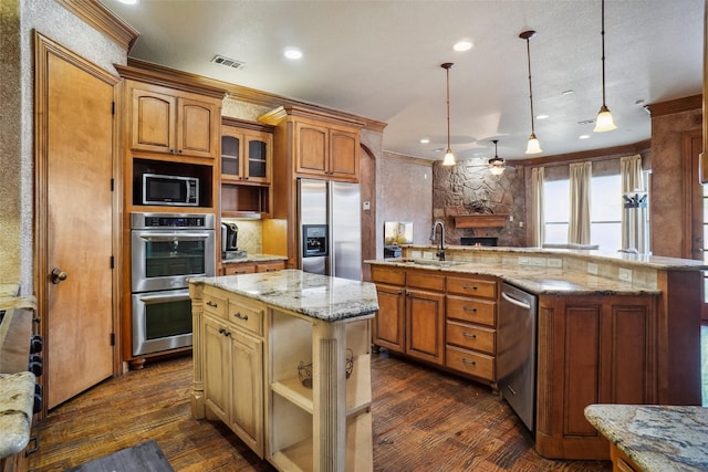 kitchen featuring pendant lighting, stainless steel appliances, a center island, and sink