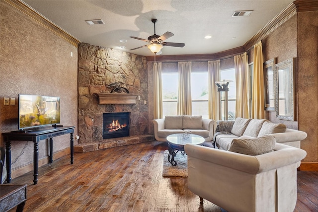 living room with a fireplace, ornamental molding, dark hardwood / wood-style floors, and a textured ceiling