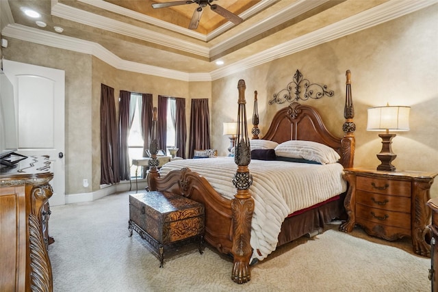 bedroom featuring ceiling fan, light colored carpet, ornamental molding, and a tray ceiling