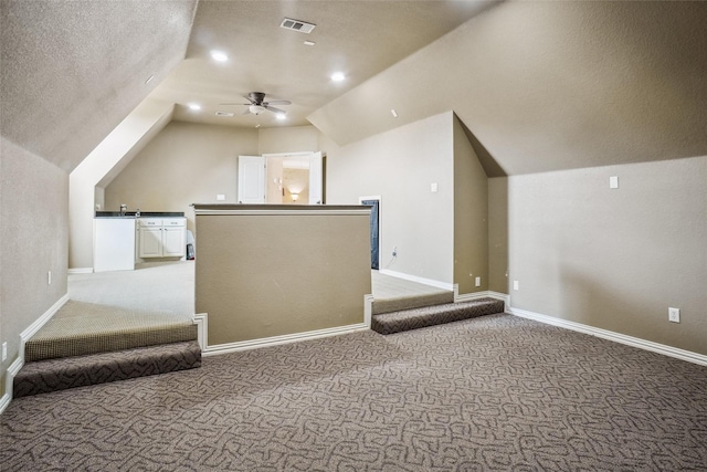 bonus room with ceiling fan, lofted ceiling, carpet floors, and a textured ceiling