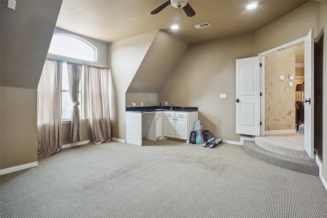 additional living space with light carpet and ceiling fan