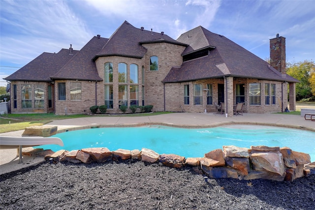 view of pool featuring a water slide and a patio