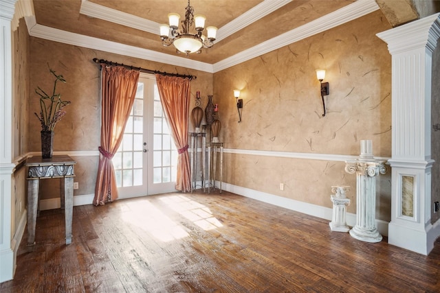 empty room with french doors, a raised ceiling, and decorative columns