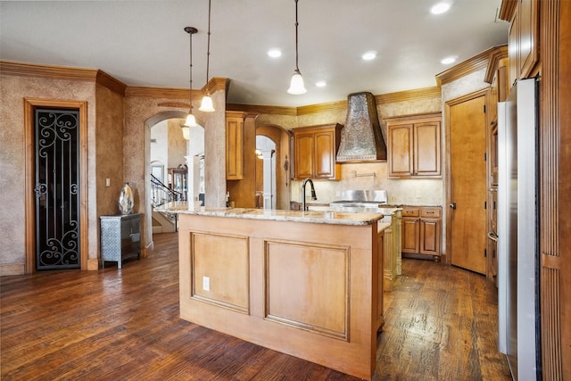 kitchen featuring premium range hood, stainless steel refrigerator, decorative light fixtures, dark hardwood / wood-style flooring, and light stone counters