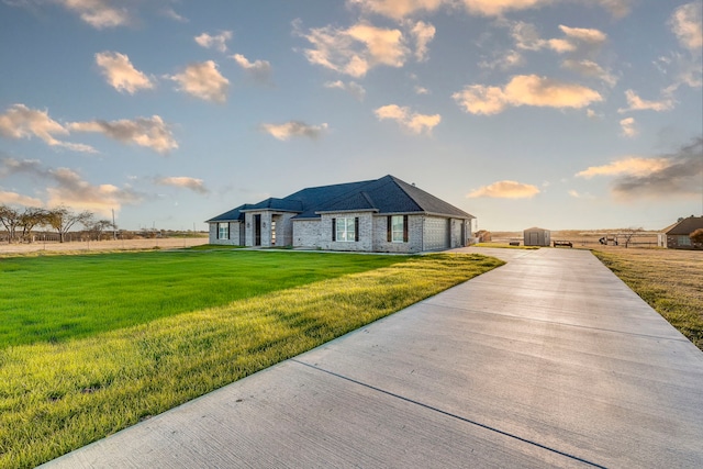 view of front of home featuring a garage, an outbuilding, driveway, and a front lawn