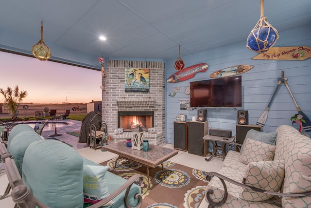 living room featuring wood walls and an outdoor brick fireplace