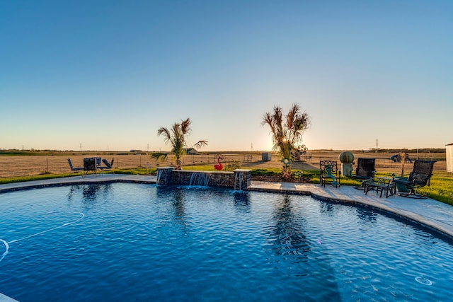 pool at dusk with pool water feature and a patio