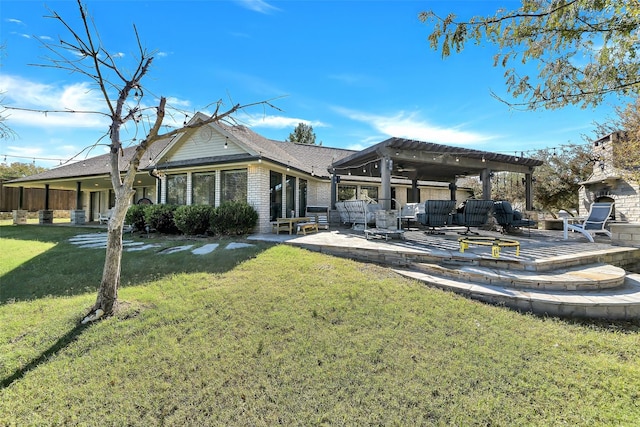 rear view of property with a patio area, a yard, and a fireplace