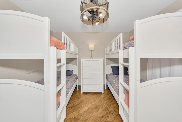 bedroom featuring an inviting chandelier and light hardwood / wood-style flooring