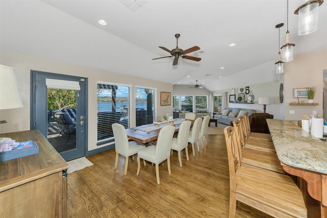 dining room featuring ceiling fan, wood-type flooring, and lofted ceiling