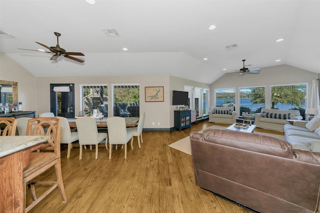 living room with light wood-type flooring, vaulted ceiling, a wealth of natural light, and ceiling fan