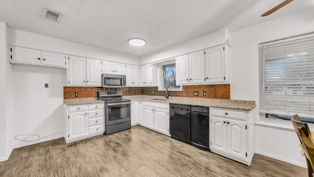 kitchen featuring light wood-type flooring, stainless steel appliances, white cabinetry, and sink