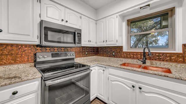 kitchen featuring white cabinets, decorative backsplash, sink, and stainless steel appliances