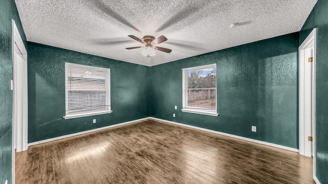 empty room featuring a textured ceiling, ceiling fan, and dark wood-type flooring