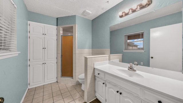 bathroom featuring tile patterned floors, a shower with shower door, a textured ceiling, and toilet