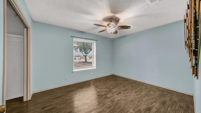 unfurnished bedroom with ceiling fan, a closet, dark wood-type flooring, and a textured ceiling