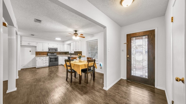 interior space with ornate columns, ceiling fan, sink, dark wood-type flooring, and a textured ceiling