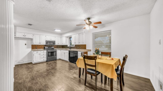 kitchen featuring white cabinets, dark hardwood / wood-style flooring, a textured ceiling, and appliances with stainless steel finishes