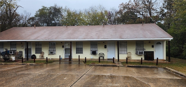 single story home featuring a porch and cooling unit