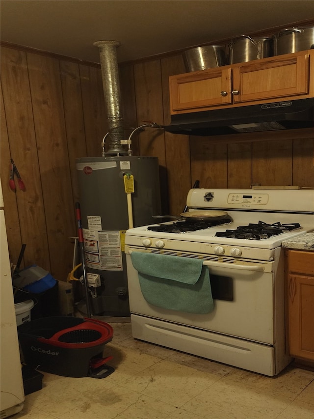 kitchen with white gas range oven, gas water heater, and wood walls