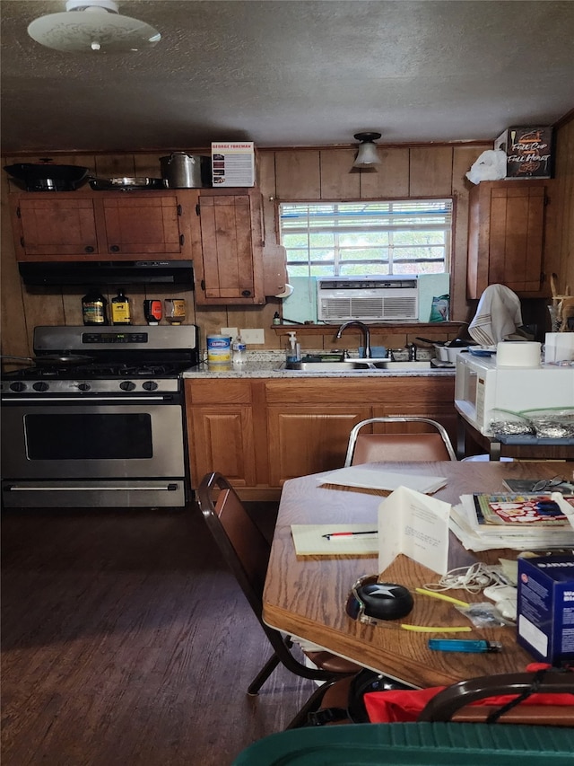 kitchen with sink, stainless steel gas stove, a textured ceiling, dark hardwood / wood-style flooring, and cooling unit