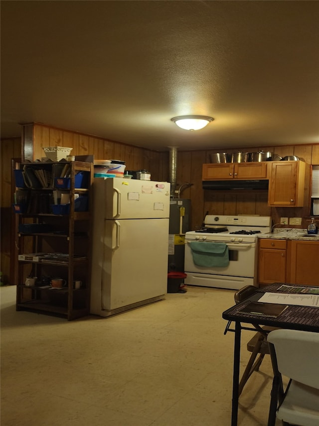 kitchen featuring a textured ceiling, wood walls, white appliances, and sink