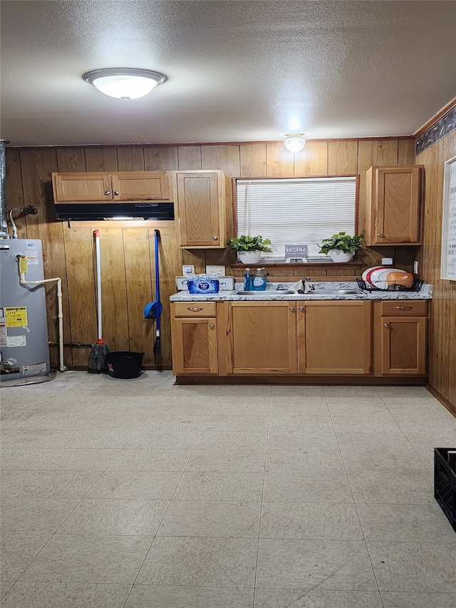 kitchen featuring stone countertops, a textured ceiling, wooden walls, and water heater