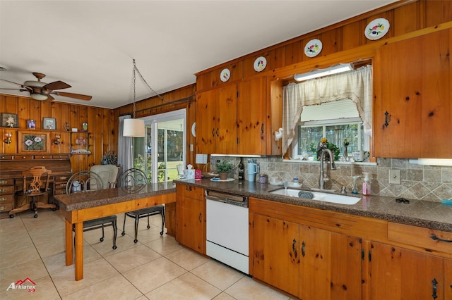 kitchen with sink, white dishwasher, tasteful backsplash, a wealth of natural light, and decorative light fixtures