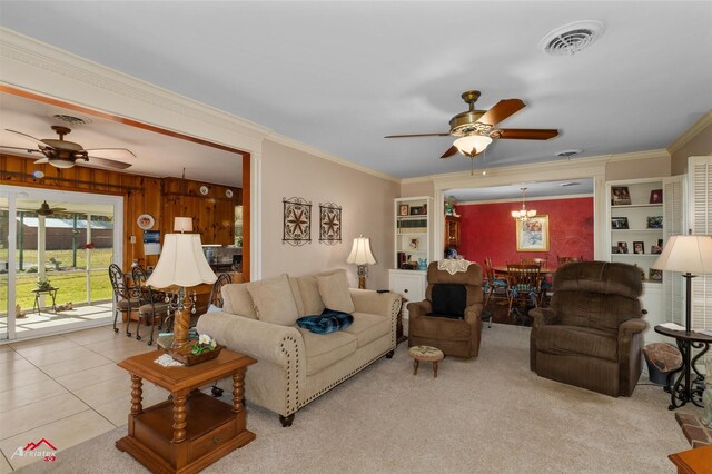 living room featuring crown molding, ceiling fan with notable chandelier, and light tile patterned flooring