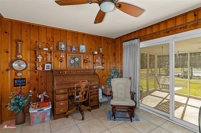 office area with light tile patterned floors, wooden walls, and ceiling fan