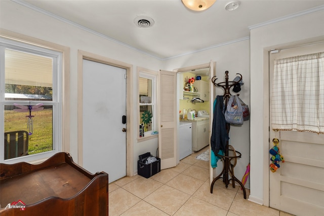 foyer entrance featuring light tile patterned floors, crown molding, and independent washer and dryer