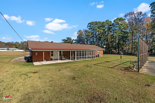 back of property with a yard, a sunroom, and a patio area