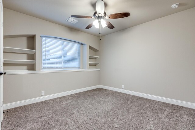 carpeted spare room featuring ceiling fan