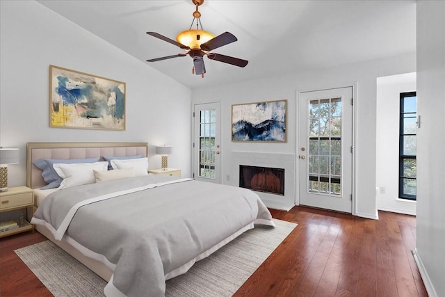 bedroom featuring access to exterior, vaulted ceiling, multiple windows, and dark wood-type flooring