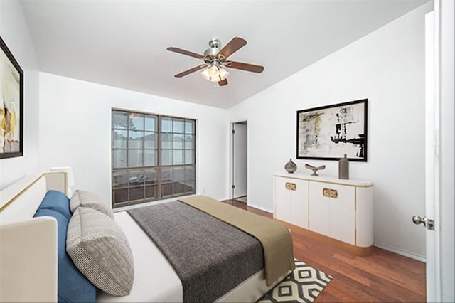 bedroom with dark hardwood / wood-style floors, vaulted ceiling, and ceiling fan