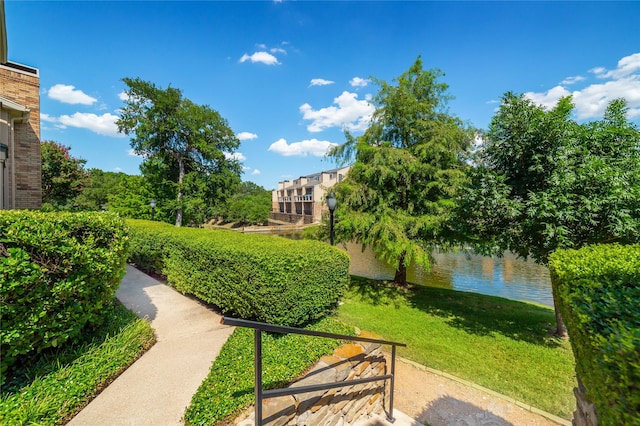 surrounding community featuring a lawn and a water view